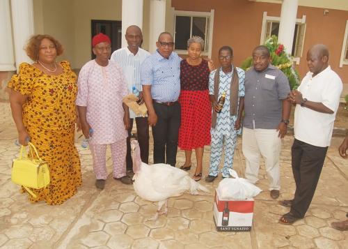 A GROUP PICTURE OF THE UCHEOGURU COMMUNITY REPRESENTATIVES / THE ADURE & ONYIMA OBIOHA FAMILY FOUNDATION WITH ITEMS DONATED TO THE FOUNDATION – A LIFE TURKEY/ CARTON OF WINE AND GARDEN EGG.